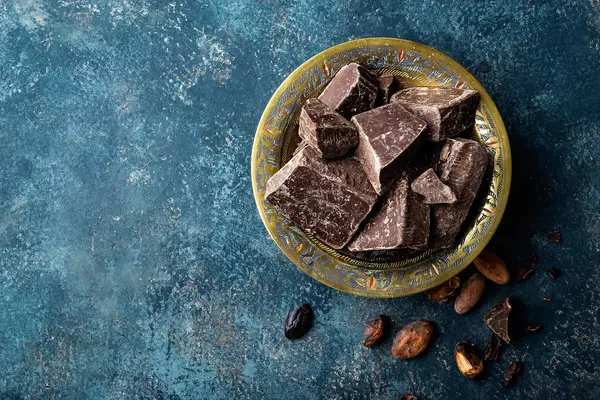 Тёмные шоколадные кусочки дробленые и какао-бобы, кулинарный фон — стоковое фото