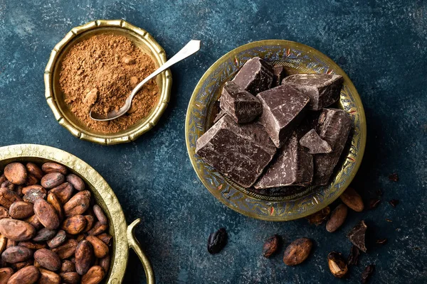 Donkere chocoladestukjes verpletterd en cacaobonen, culinaire achtergrond — Stockfoto