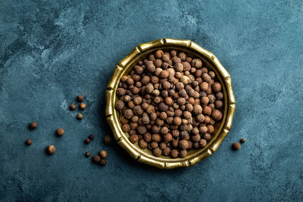 Piment peper, peperkorrels op donkere culinaire achtergrond, bovenaanzicht — Stockfoto