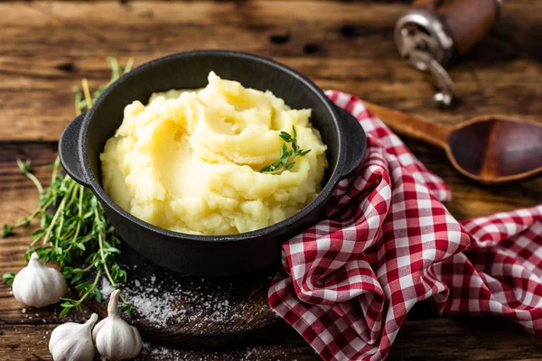 Potatismos, kokta puré i gjutjärn gryta på mörk trä rustik bakgrund — Stockfoto