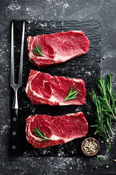 Carne cruda, filete de res sobre fondo negro, vista superior — Foto de Stock