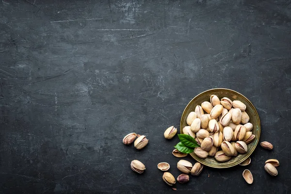 Pistachenoten op donkere achtergrond, bovenaanzicht, gezonde snack — Stockfoto