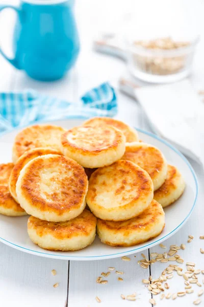 Cottage cheese pancakes with oats, syrniki on white rustic background — Stock Photo, Image