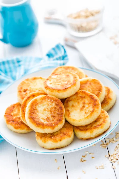 Cottage cheese pancakes with oats, syrniki on white rustic background — Stock Photo, Image