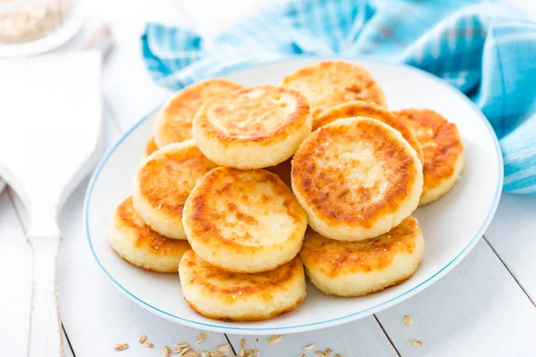 Panqueques de requesón con avena, syrniki sobre fondo rústico blanco —  Fotos de Stock