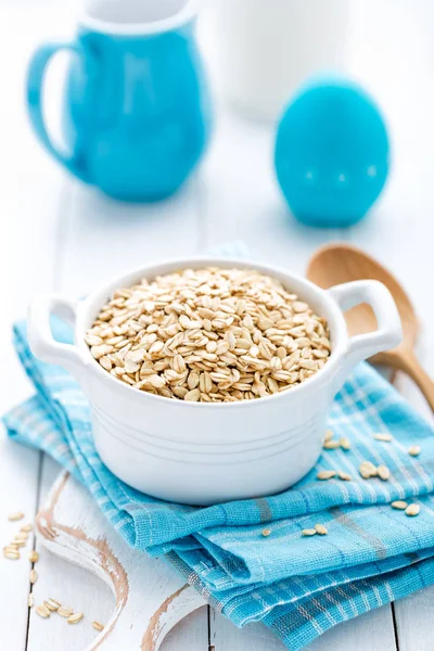 Rolled oats on white wooden background — Stock Photo, Image