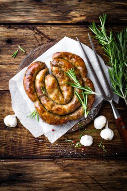 Karanlık rustik ahşap arka plan üzerinde ızgara sosis