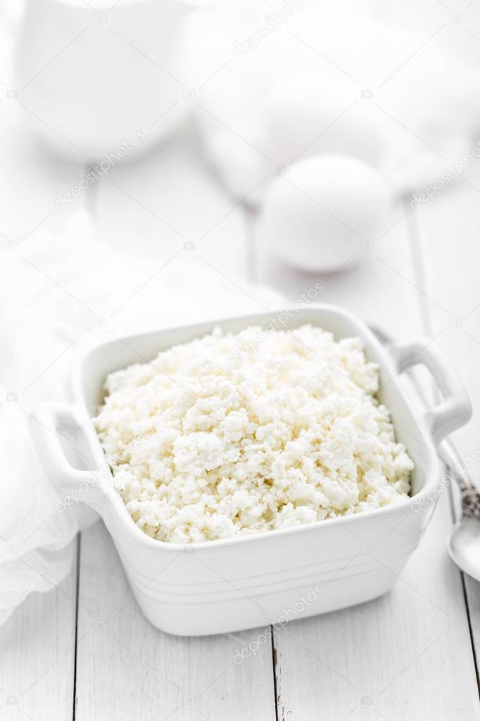 Cottage cheese on white wooden rustic background, dairy product