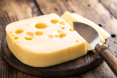 Lezzetli İsviçre peyniri koyu ahşap rustik arka plan üzerinde sarı