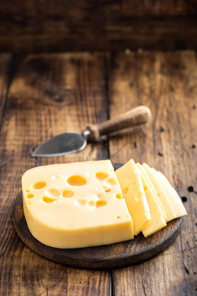 Delicious Swiss yellow cheese on dark wooden rustic background closeup — Stock Photo, Image