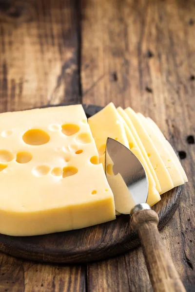 Delicioso queso amarillo suizo sobre fondo rústico de madera oscura —  Fotos de Stock