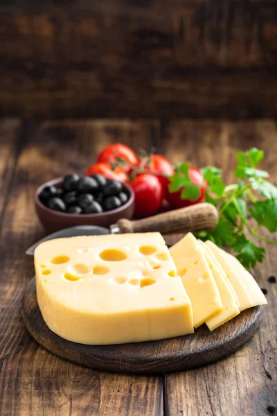 Вкусный швейцарский желтый сыр на темном деревенском фоне крупным планом — стоковое фото