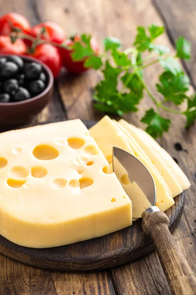 Heerlijke Zwitserse gele kaas op donkere houten rustieke achtergrond closeup — Stockfoto