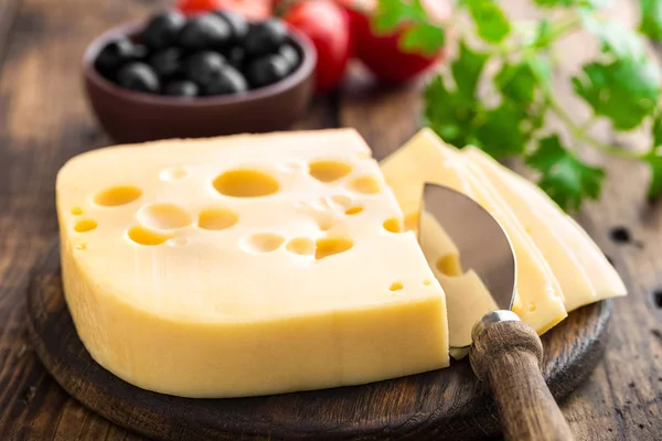 Delicious Swiss yellow cheese on dark wooden rustic background closeup — Stock Photo, Image