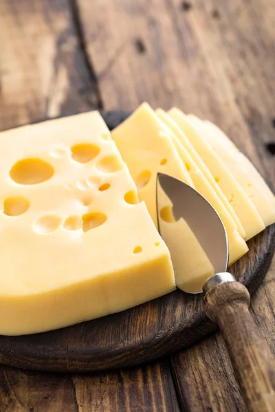 Вкусный швейцарский желтый сыр на темном деревенском фоне крупным планом — стоковое фото