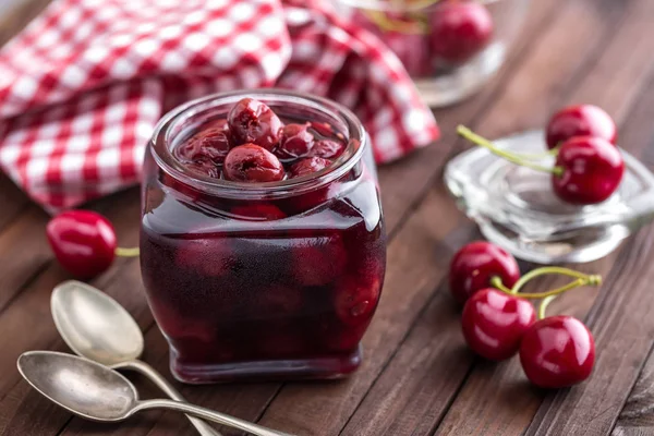 Berries cherry with syrup in a glass jar. Canned fruit — Stock Photo, Image