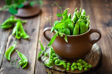 Koyu ahşap rustik arka plan üzerinde taze yeşil bezelye