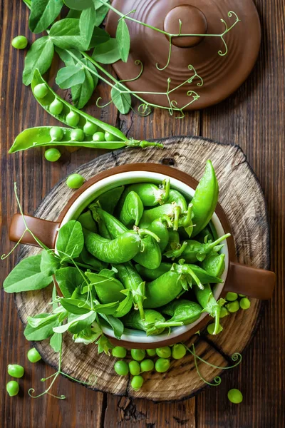 Fresh green peas on dark wooden rustic background — Stock Photo, Image