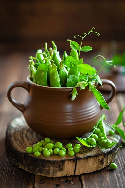 Fresh green peas on dark wooden rustic background — Stock Photo, Image