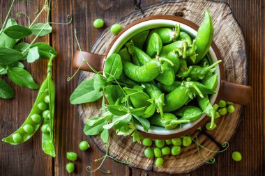 Koyu ahşap rustik arka plan üzerinde taze yeşil bezelye