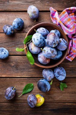 Ahşap rustik arka plan, üstten görünüm üzerinde yeşil yaprakları ile taze Erik