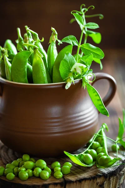 Fresh green peas on dark wooden rustic background — Stock Photo, Image