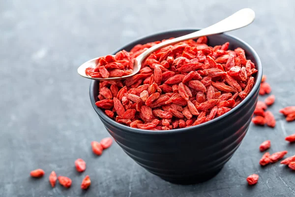 Bacche di Goji in ciotola su sfondo scuro primo piano — Foto Stock