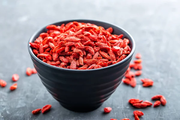 Bacche di Goji in ciotola su sfondo scuro primo piano — Foto Stock