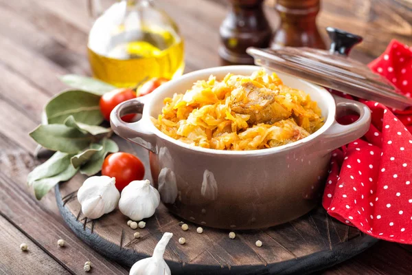 Тушкована капуста з м'ясом на темному сільському дерев'яному фоні — стокове фото