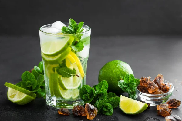 Refrescante cóctel de menta mojito con ron y lima, bebida fría o bebida con hielo sobre fondo negro —  Fotos de Stock