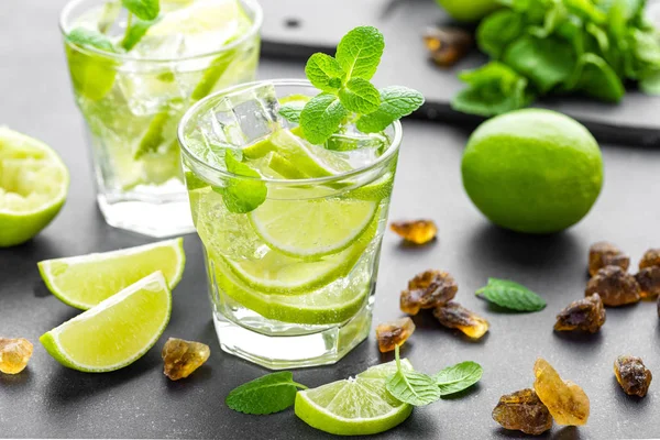 Zomer mint lime verfrissende cocktail mojito met rum en ijs in glas op zwarte achtergrond bovenaanzicht — Stockfoto