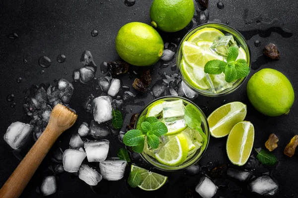 Uppfriskande mint cocktail mojito med Rom och lime, kall dryck eller dryck med is på svart bakgrund, ovanifrån — Stockfoto