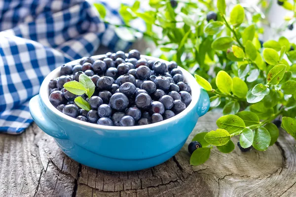 Frische Blaubeeren mit Blättern auf hölzernem Hintergrund — Stockfoto