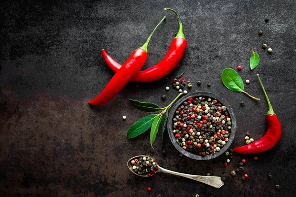 Red hot chili pepeprs és bors-fekete fém háttér, felülnézet — Stock Fotó