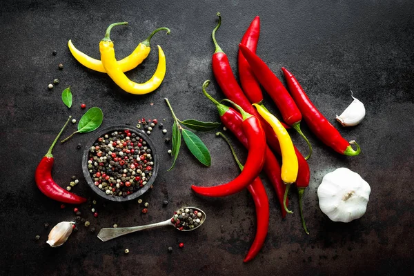 Red hot chili pepeprs and peppercorns on black metal background, top view — Stock Photo, Image