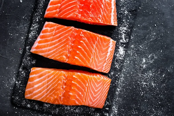 Filete de salmón crudo sobre fondo de pizarra oscura, pescado atlántico salvaje — Foto de Stock