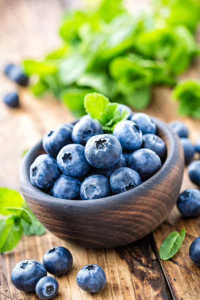 Frische Blaubeeren in Schale auf Holztisch — Stockfoto