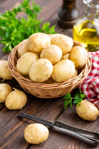 Syrové brambory v koši na dřevěný stůl closeup — Stock fotografie