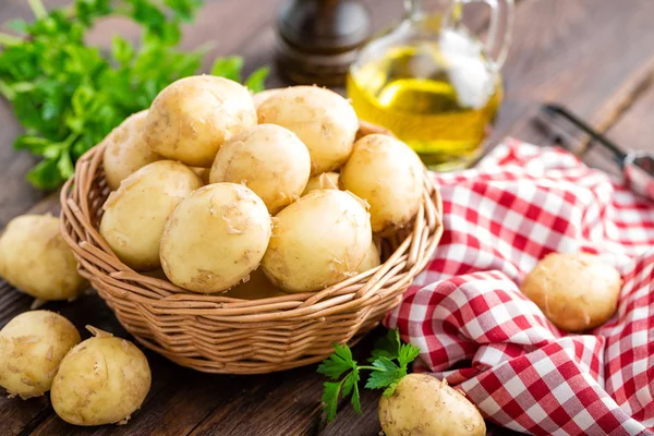 Raw potato in basket on wooden table closeup — Stock Photo, Image