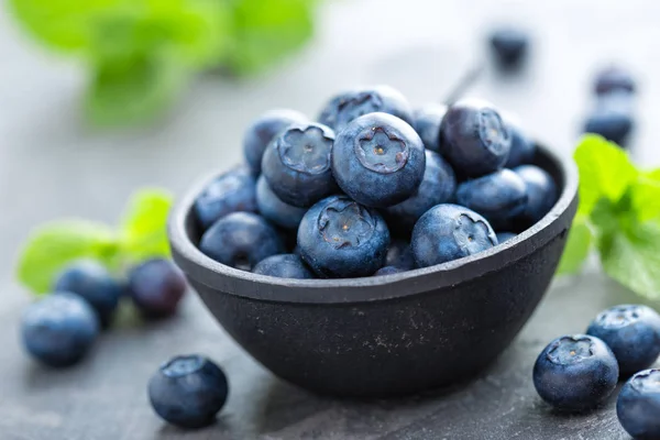 Frische Blaubeeren in einer Schüssel auf dunklem Hintergrund, Draufsicht. saftige Waldbeeren, Heidelbeeren. gesunde Ernährung oder Ernährung. — Stockfoto