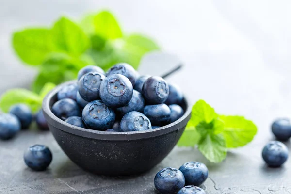 Frische Blaubeeren in einer Schüssel auf dunklem Hintergrund, Draufsicht. saftige Waldbeeren, Heidelbeeren. gesunde Ernährung oder Ernährung. — Stockfoto