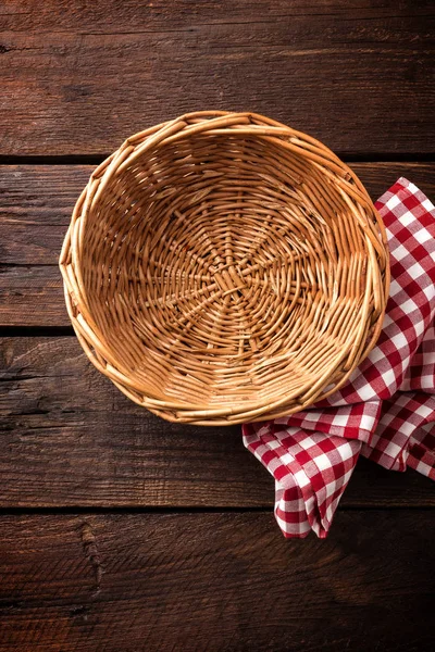 Lege rieten mand op houten achtergrond, bovenaanzicht — Stockfoto