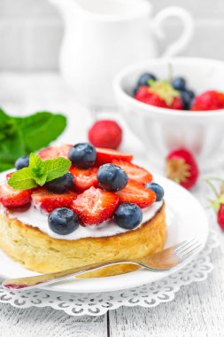 Lezzetli berry cheesecake taze çilek ve beyaz arka plan üzerinde yaban mersini ile