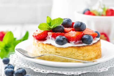 Lezzetli berry cheesecake taze çilek ve beyaz arka plan üzerinde yaban mersini ile