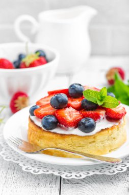 Lezzetli berry cheesecake taze çilek ve beyaz arka plan üzerinde yaban mersini ile