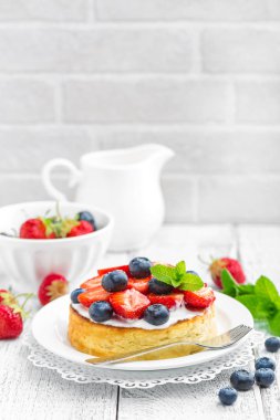 Lezzetli berry cheesecake taze çilek ve beyaz arka plan üzerinde yaban mersini ile