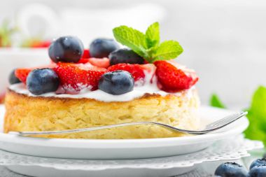 Lezzetli berry cheesecake taze çilek ve beyaz arka plan üzerinde yaban mersini ile