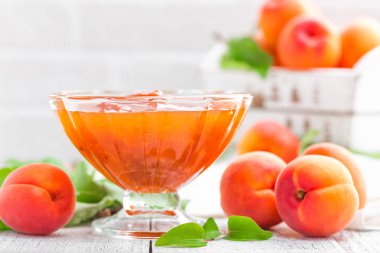 Kayısı reçeli ve Beyaz ahşap masa yapraklarda ile taze meyve