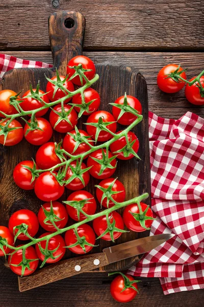 Fresh cherry tomatoes on twigs on wooden table, top view — Stock Photo, Image