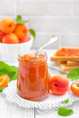 Kayısı reçeli bir kavanoz ve Beyaz ahşap masa yapraklarda ile taze meyve, Odaya Servis Kahvaltı